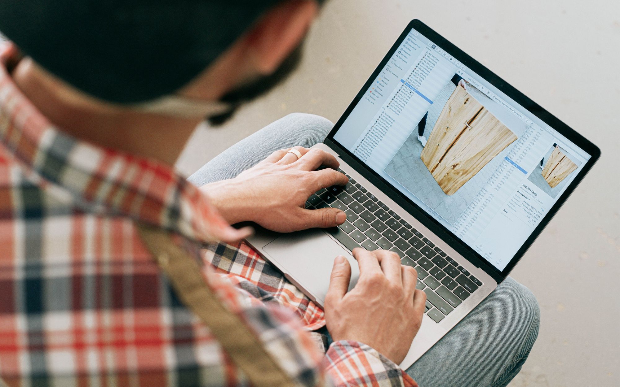 Craftsperson using a laptop in a woodworking workshop
