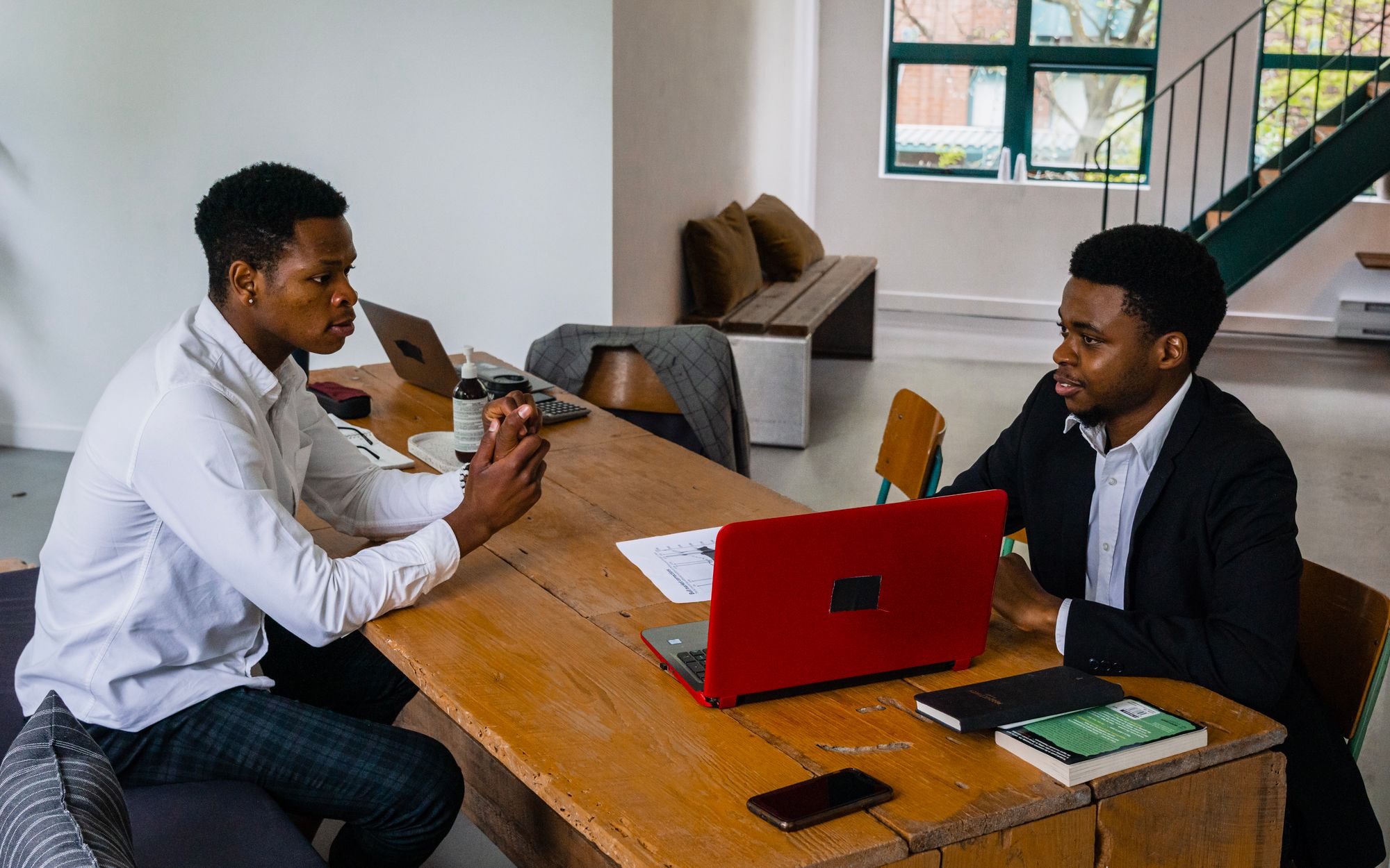 Two business owners discussing work around a laptop