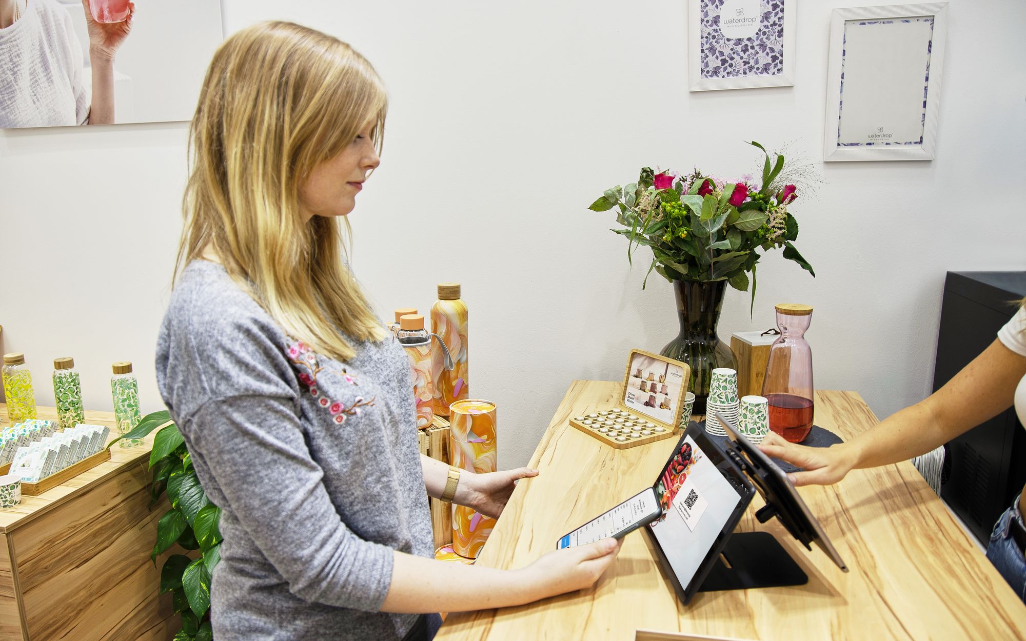 Customer using a tablet at the counter of an independent shop